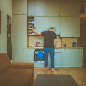 man facing on gray wooden cabinet picking container